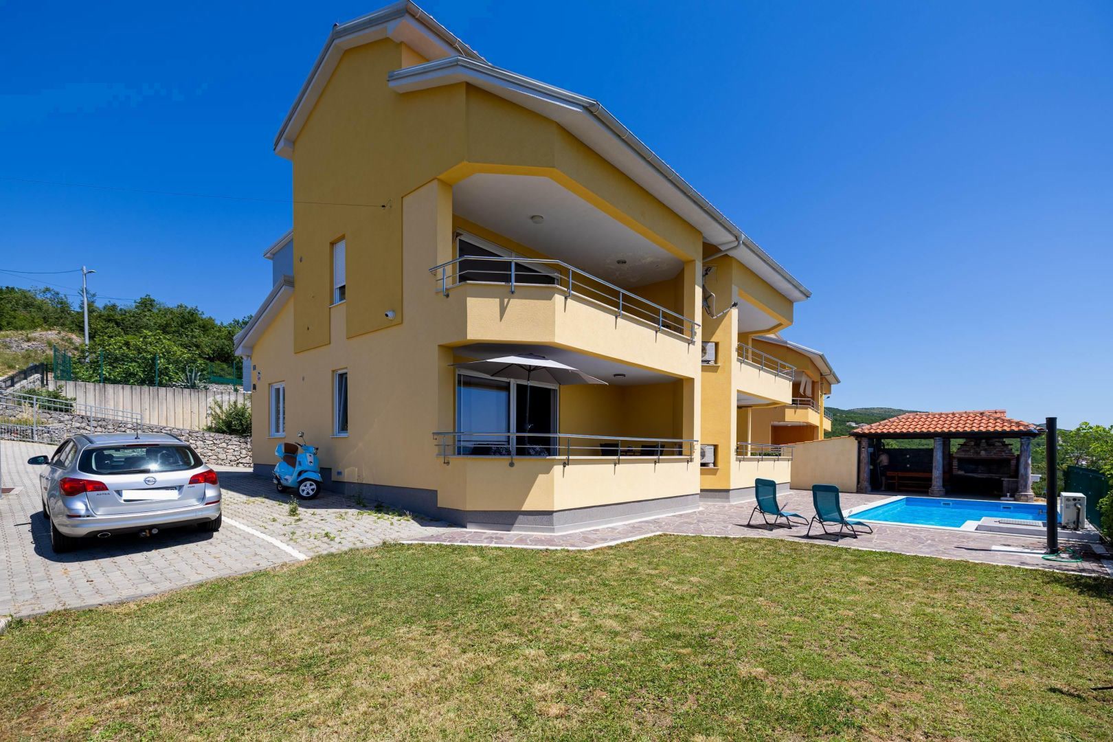 Yellow residential building with parking space and lawn