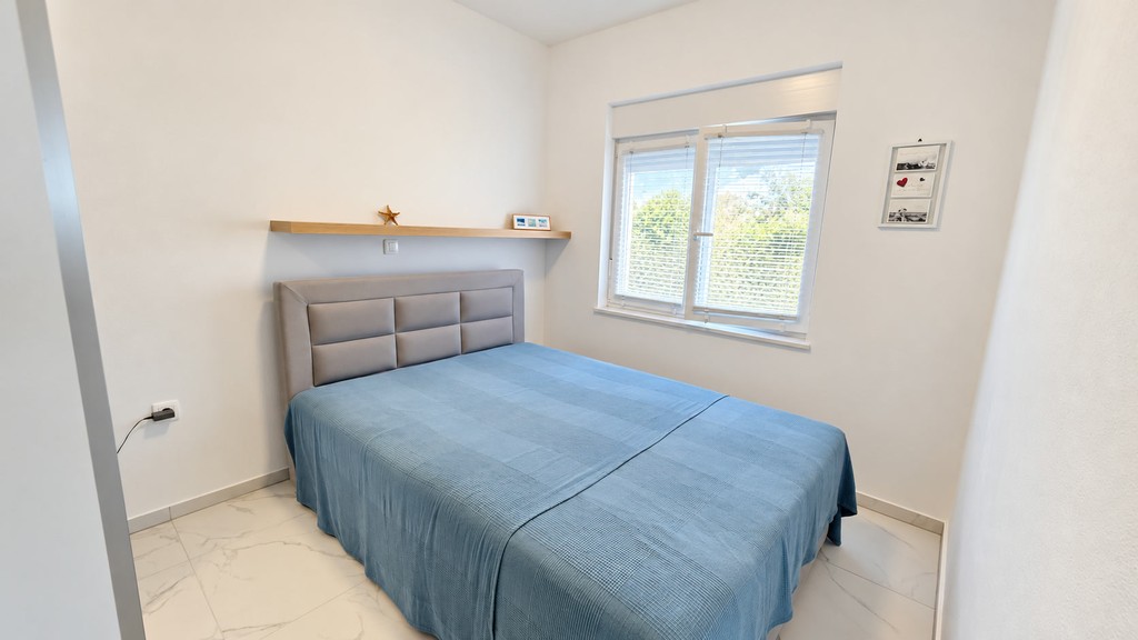 Bedroom with wall shelf and window