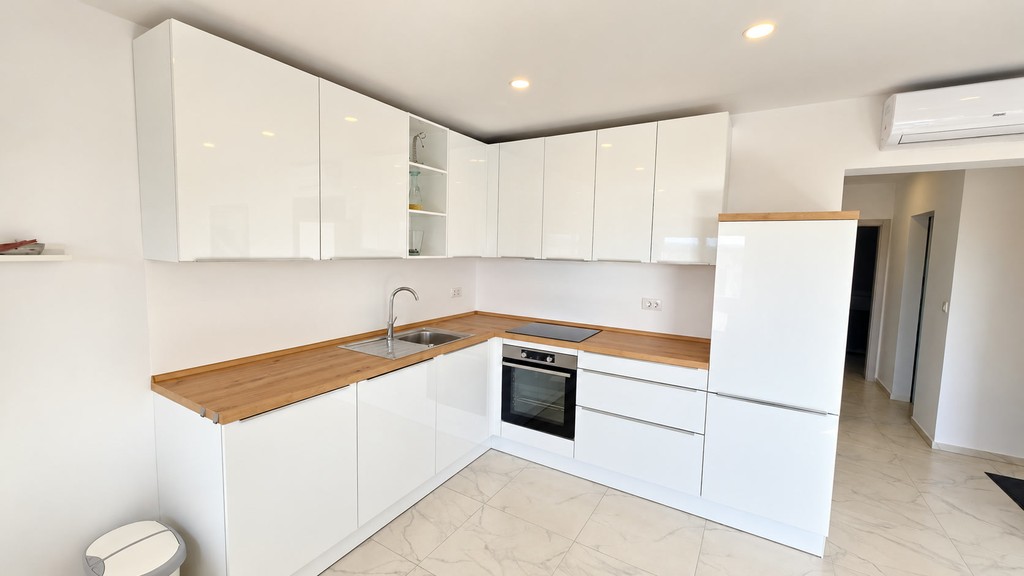White fitted kitchen with wooden worktop