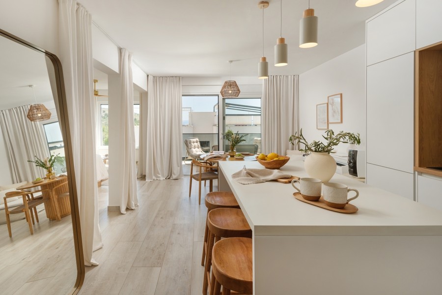 Open-plan kitchen with bar stools and view of the terrace