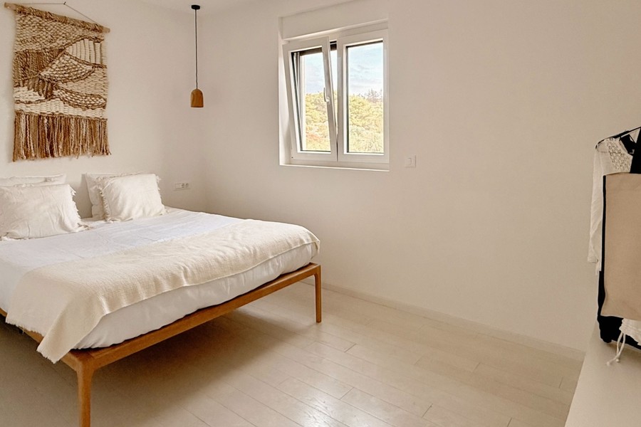 Second bedroom with wooden bed and window