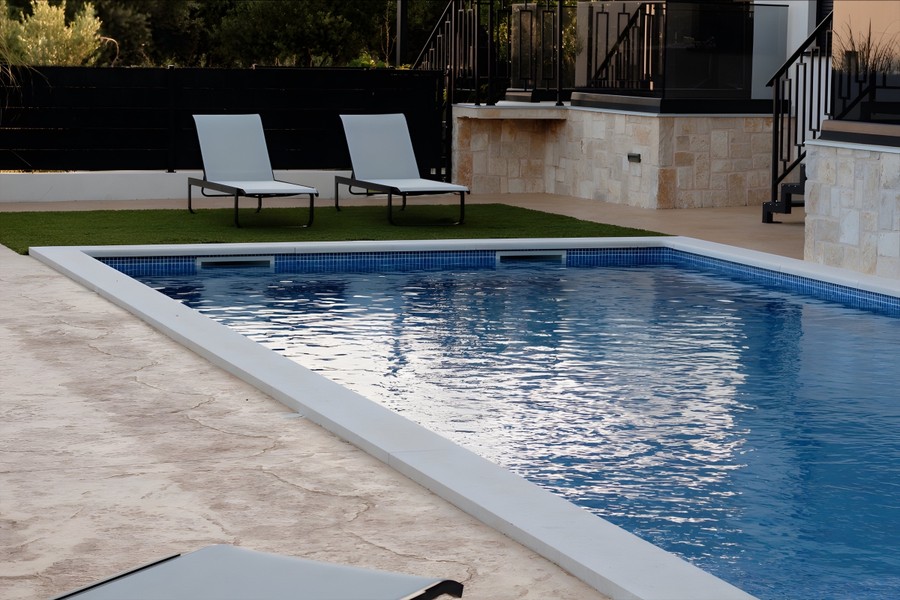 Swimming pool with lawn and sun loungers