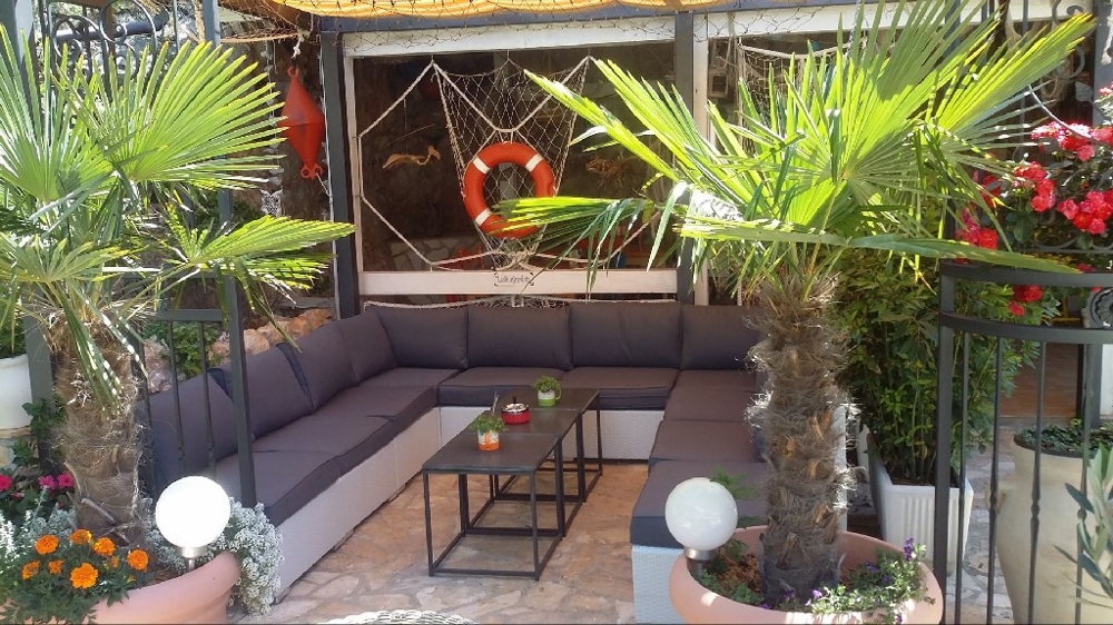 Covered terrace with some plants of the villa - multi-family house for sale in Croatia.
