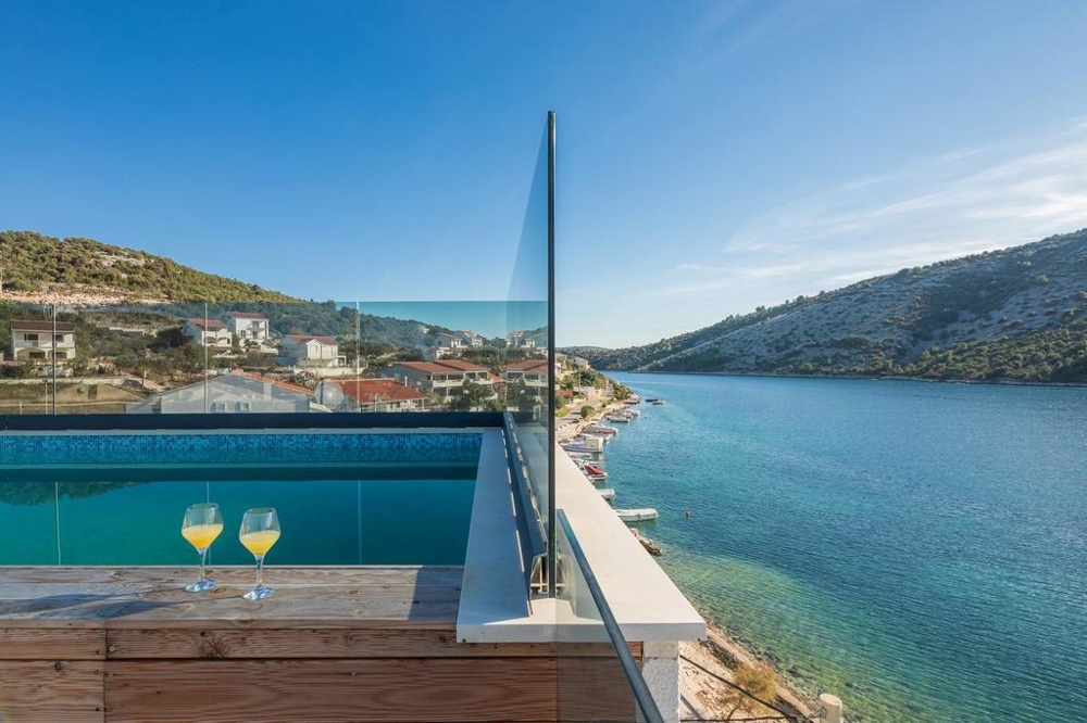 Glasses by the pool with a view across the channel to the slope