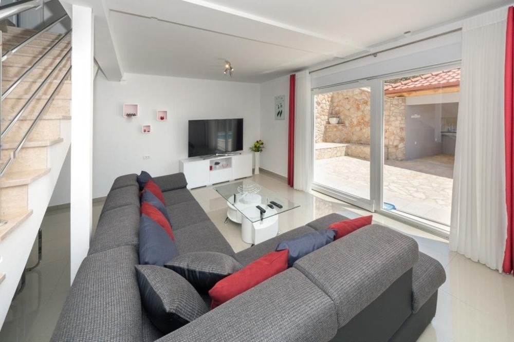 Living room with a view of the terrace with a large sofa - Panorama Scouting.