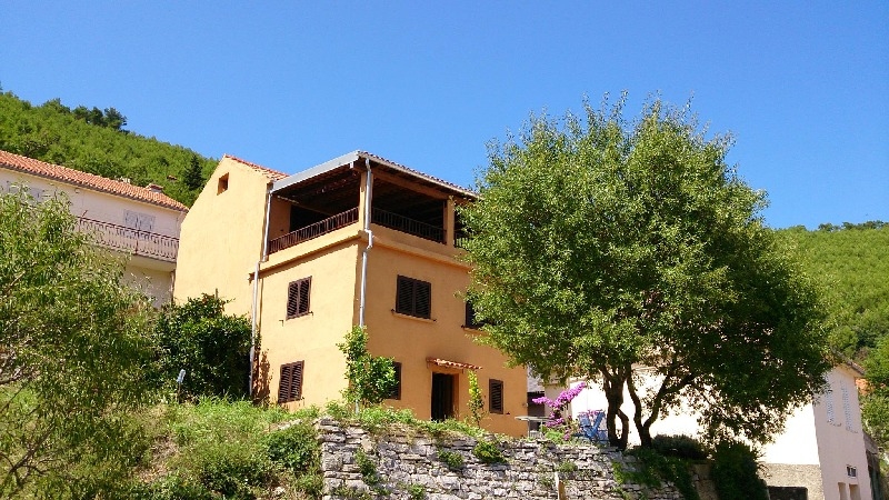 View of the back of the house with a view of the large covered balcony - buy a stone house in Croatia.