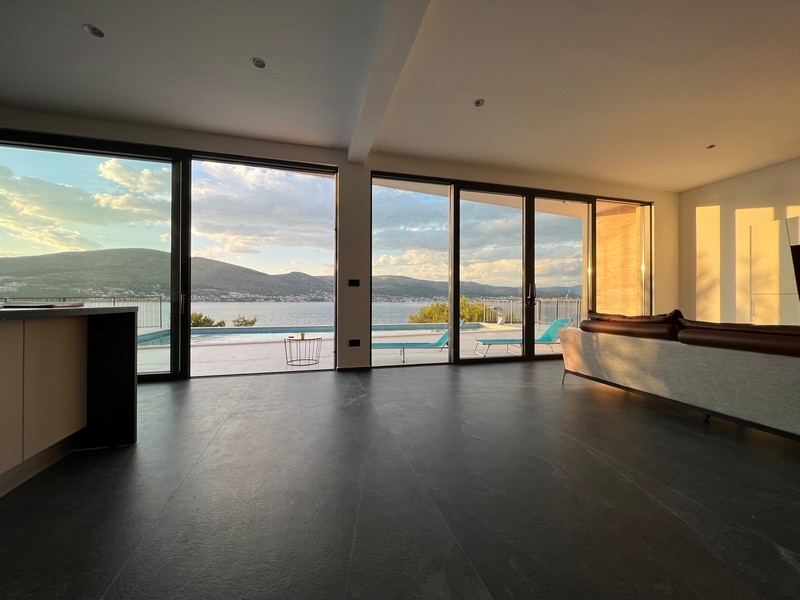 Living space with window front and pool in the evening light