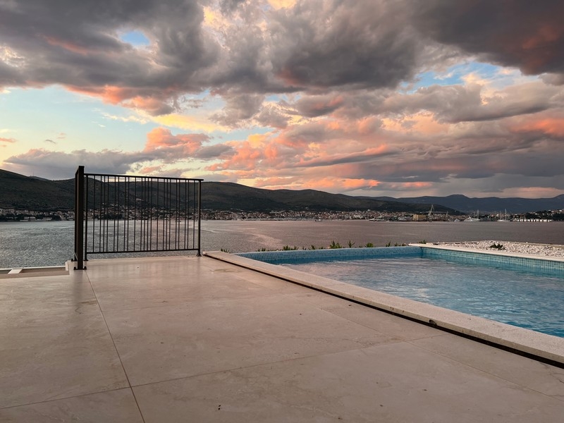Pool terrace with view of the bay under pink evening clouds