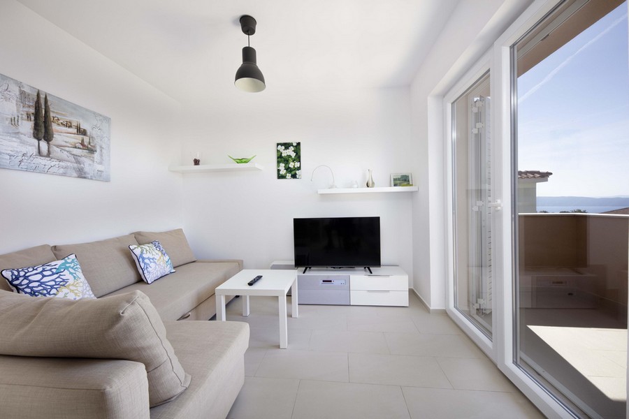 Living room with beige sofa and sliding door to the balcony