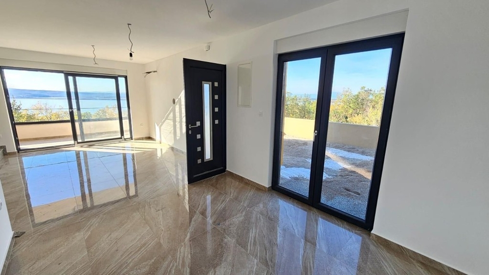Living room with tiled floor and floor-to-ceiling windows facing the sea - H2197