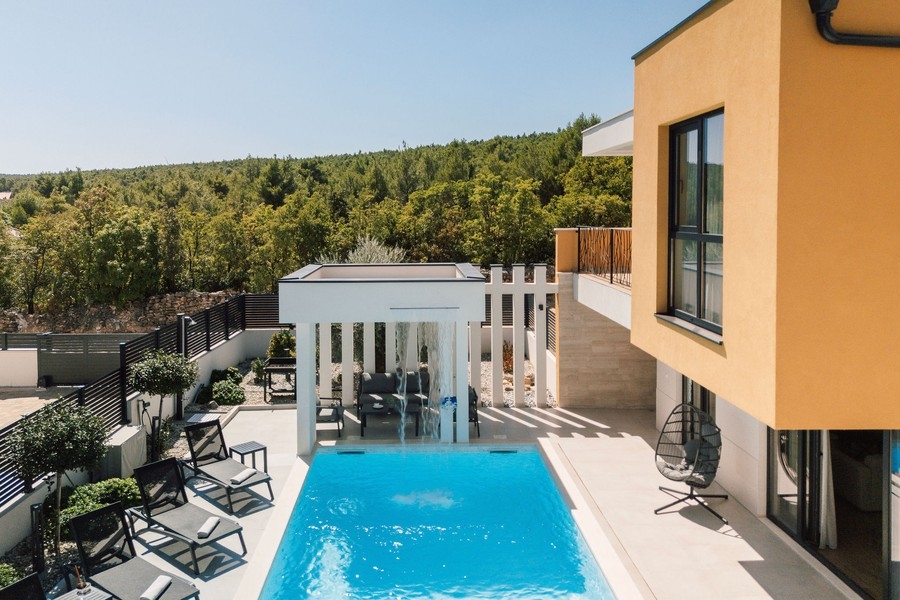 Pool with covered seating area and a view of the greenery