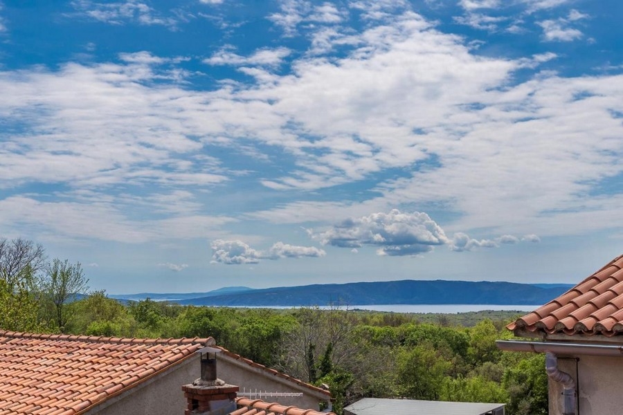 Cloudy sky above tiled roofs and the bay