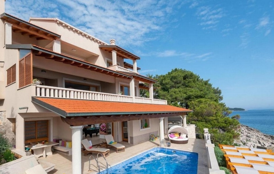 House with balustrades and pool directly above the rocky coast