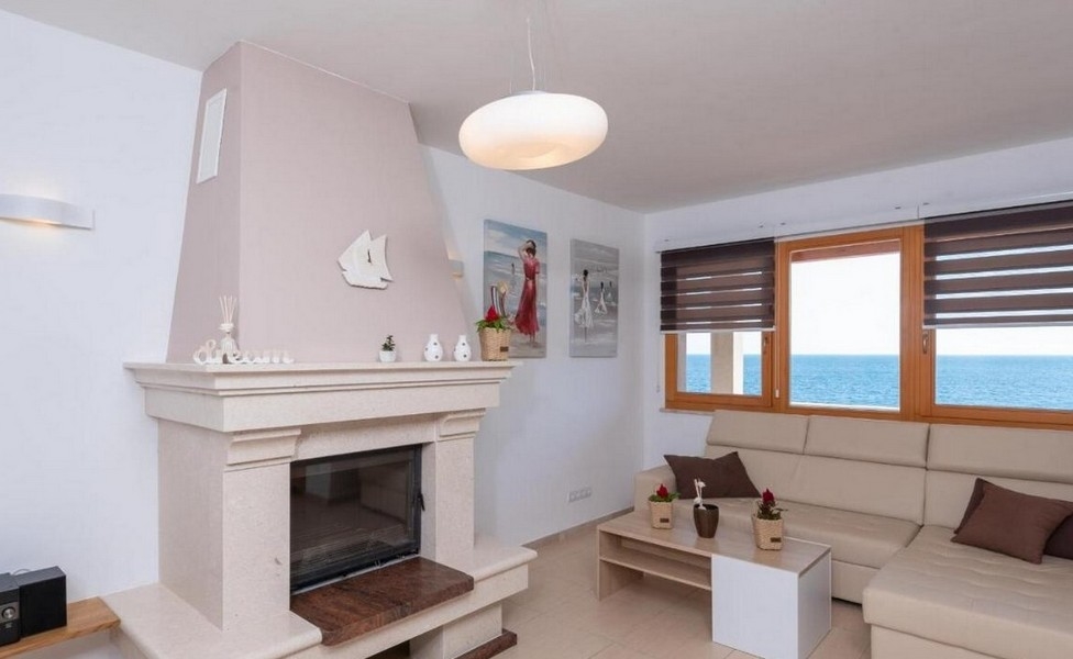 Fireplace in the living room with sea views and a bright couch.