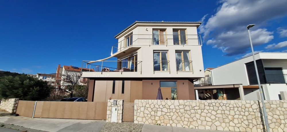 Front view of a modern villa in Croatia with a beige facade and large balconies