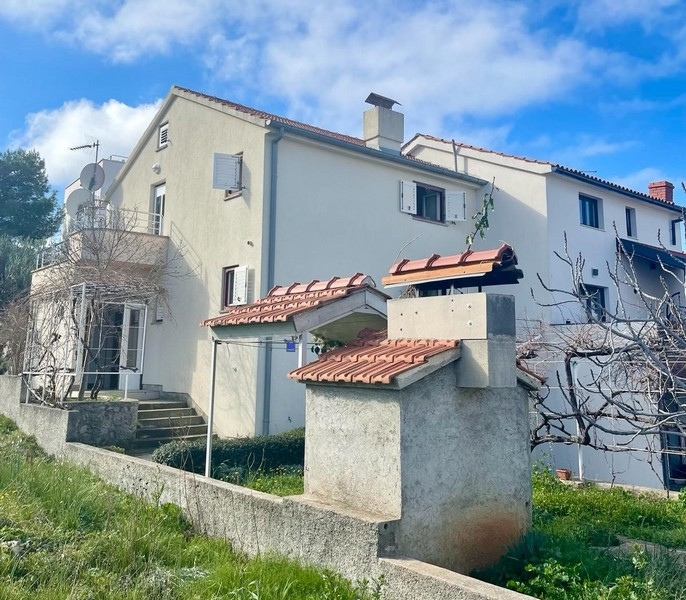 Side view of semi-detached house for sale with external stairs and satellite dish, near the sea in Zaboric, Croatia