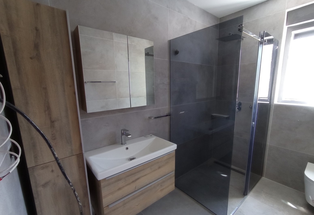 Modern bathroom with walk-in shower in a property in Croatia, mirror cabinet and wooden elements in the design.