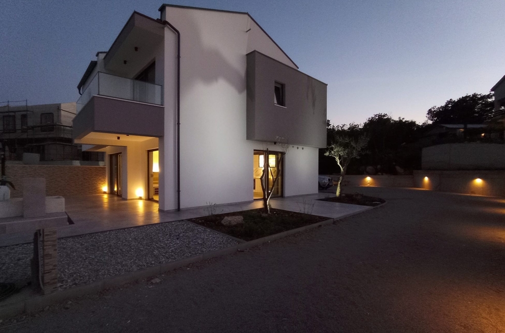 Side view of a property in Croatia at dusk with illuminated path and entrance.