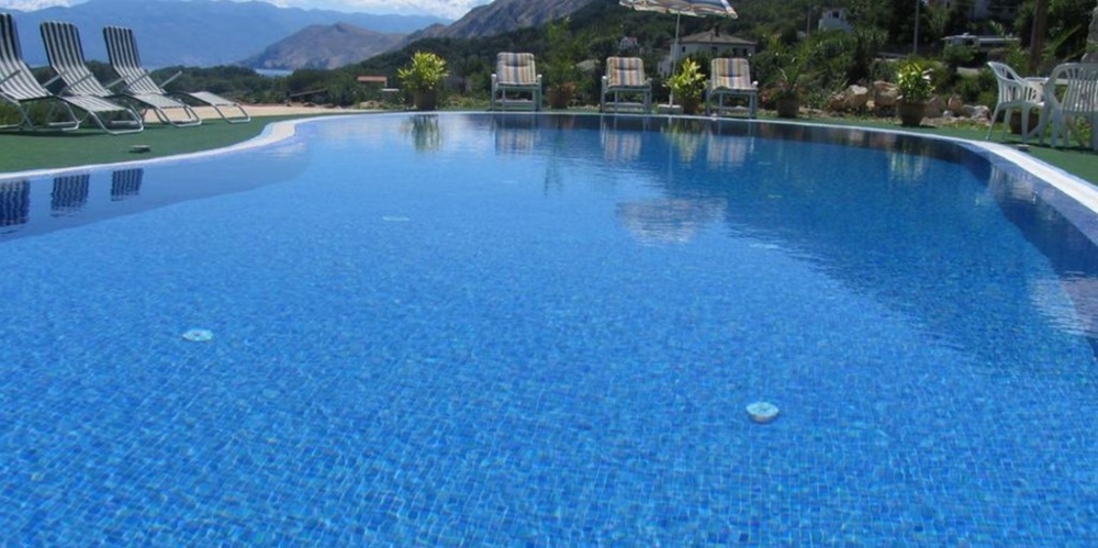Large swimming pool with loungers at the edge of the pool