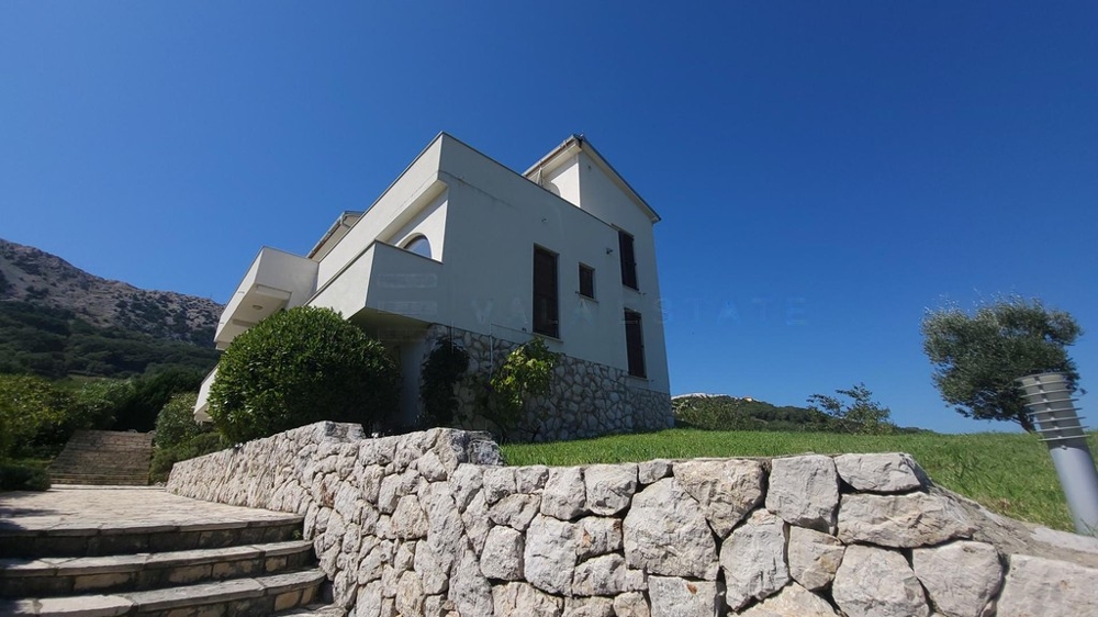 House with natural stone wall, lawn and steps