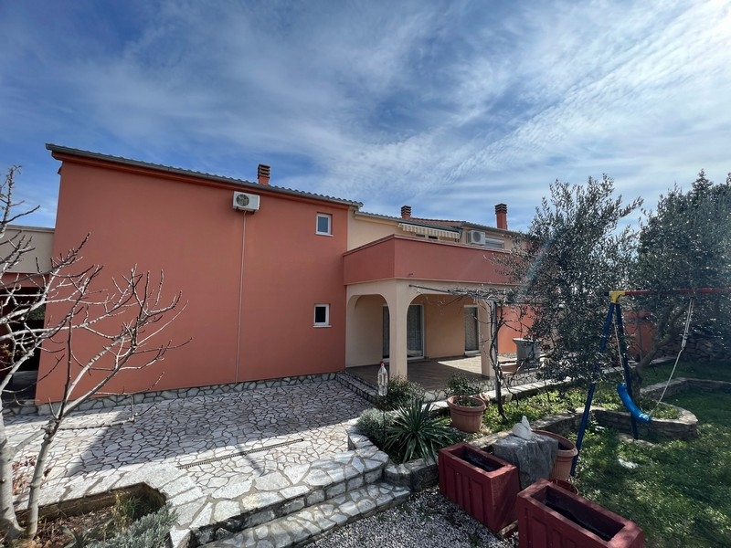 Real Estate Croatia, City of Krk, Island of Krk Buying an apartment building, side view of the house with veranda and garden area