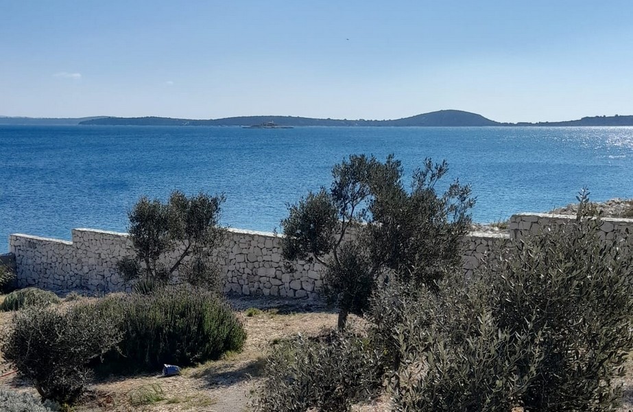 Real estate Croatia, house right by the sea - Panorama Scouting H3015: View of the sea from a covered terrace with loungers and a parasol.