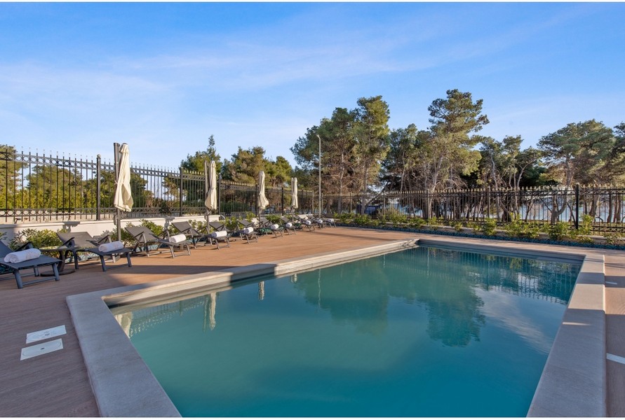 Swimming pool and sun loungers near the sea shore in Vodice, Croatia.