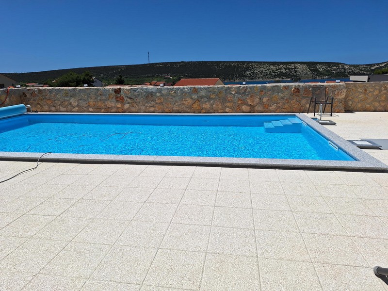 Swimming pool and Mediterranean stone wall on the sun terrace.