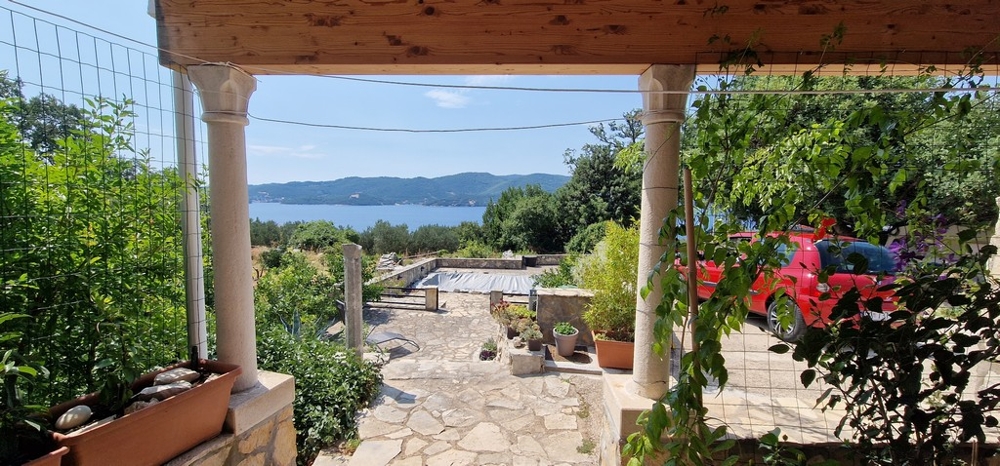 Covered terrace with a view of the covered pool and the sea.