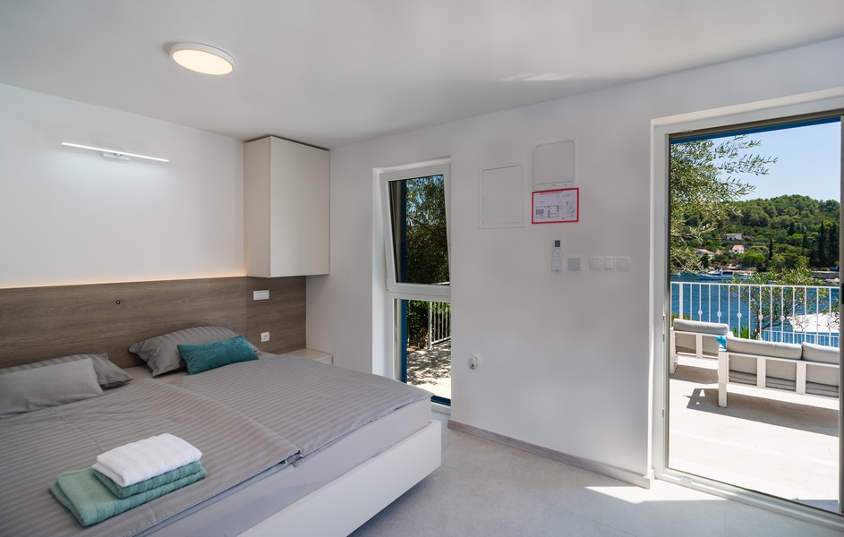 Bedroom with double bed and access to the balcony with sea view