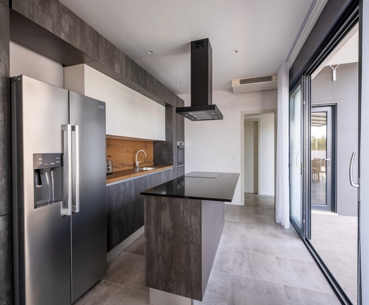 Modern kitchen with cooking island and terrace access