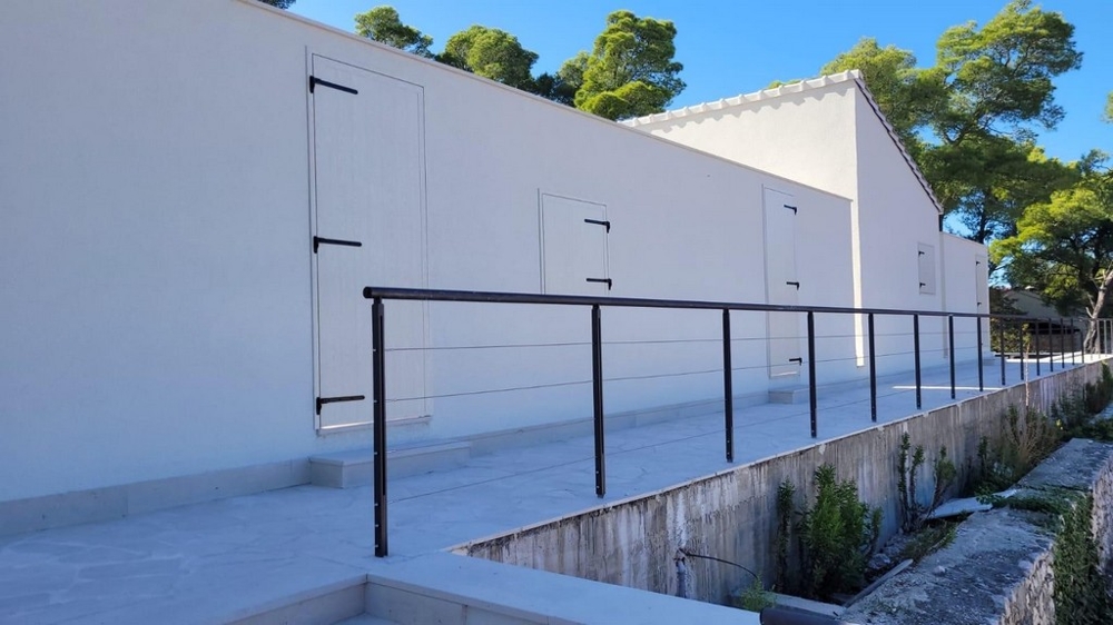 Exterior view of modern house with white facade and railing