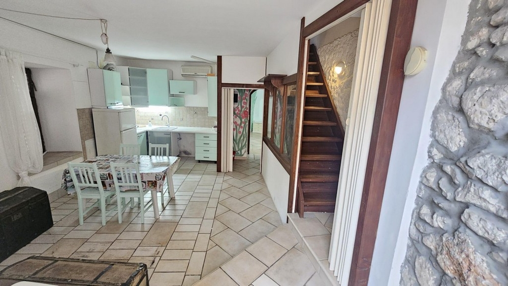 Living area with kitchen and wooden stairs