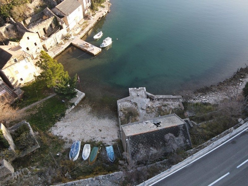 Aerial view of a small bay with boats and stone houses on the water