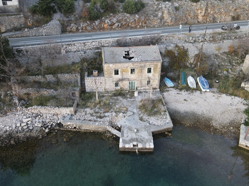 Stone house in need of renovation in the first row to the sea