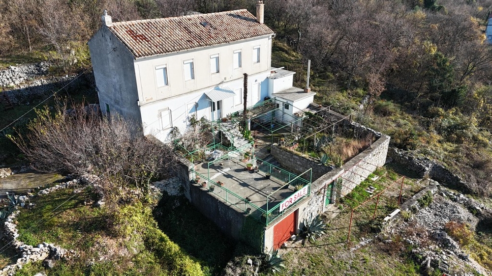 House in need of renovation on a large plot of land on a hillside