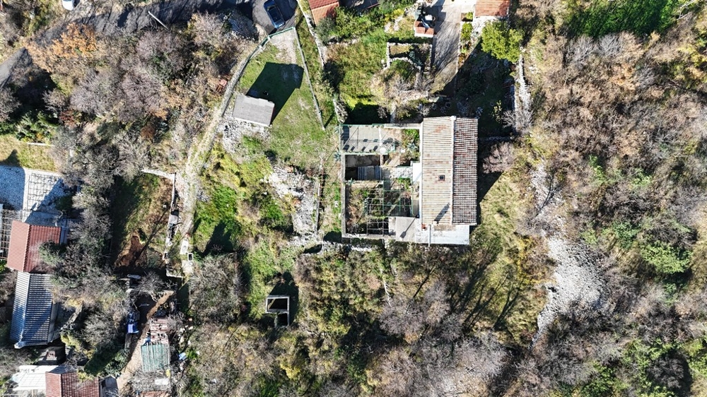 Aerial view of the house with surrounding land and vegetation