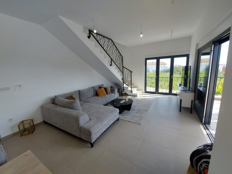 Bright living area with sofa and stairs