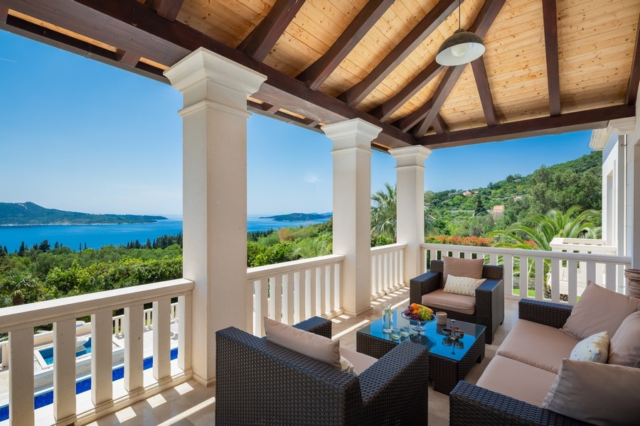 Covered terrace with seating area and sea views