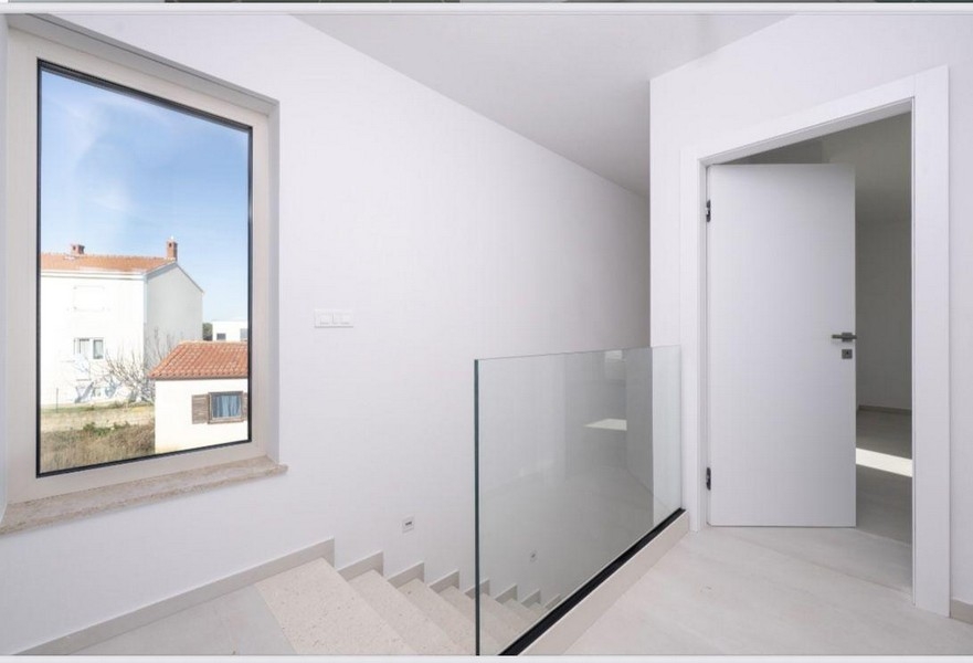 Staircase with glass railings on the upper floor