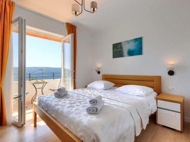 Bright bedroom with double bed and sea view