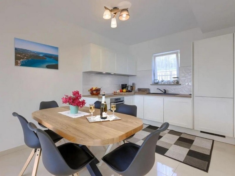 Dining area with wooden table and open kitchen