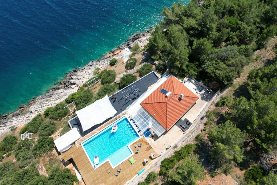 Aerial view of the villa in the first row to the sea with pool and sun terrace