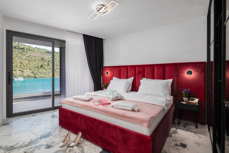 Bedroom with red upholstered bed and sea view