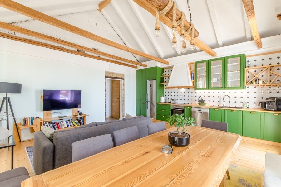 Living area with open kitchen and wooden beamed ceiling
