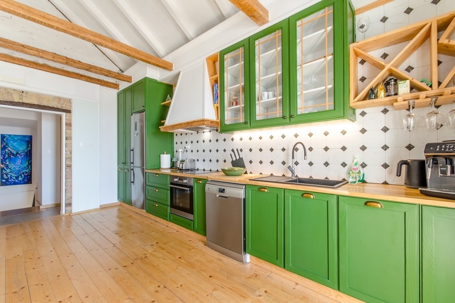 Modern kitchen with green fronts and wooden elements