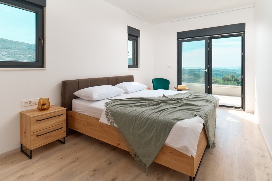 Bedroom with double bed and access to the balcony with distant views