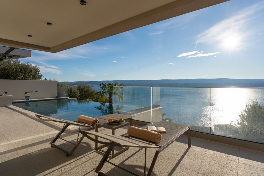 Infinity pool with glass railings and views over the coast