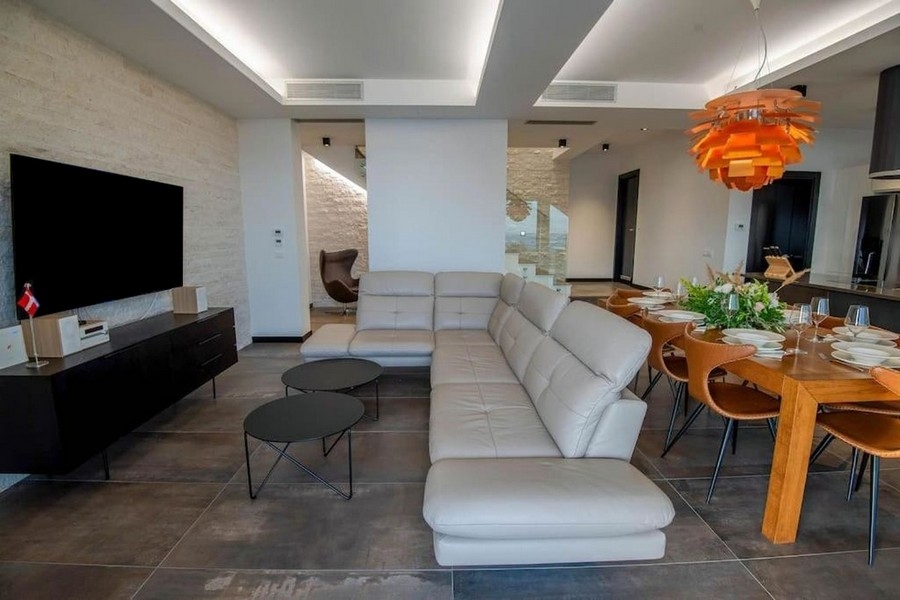 Modern living area with sofa, TV and open dining area