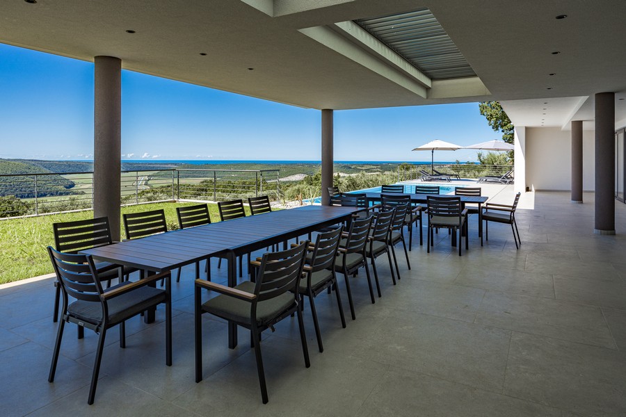 Covered terrace with large dining table and panoramic views
